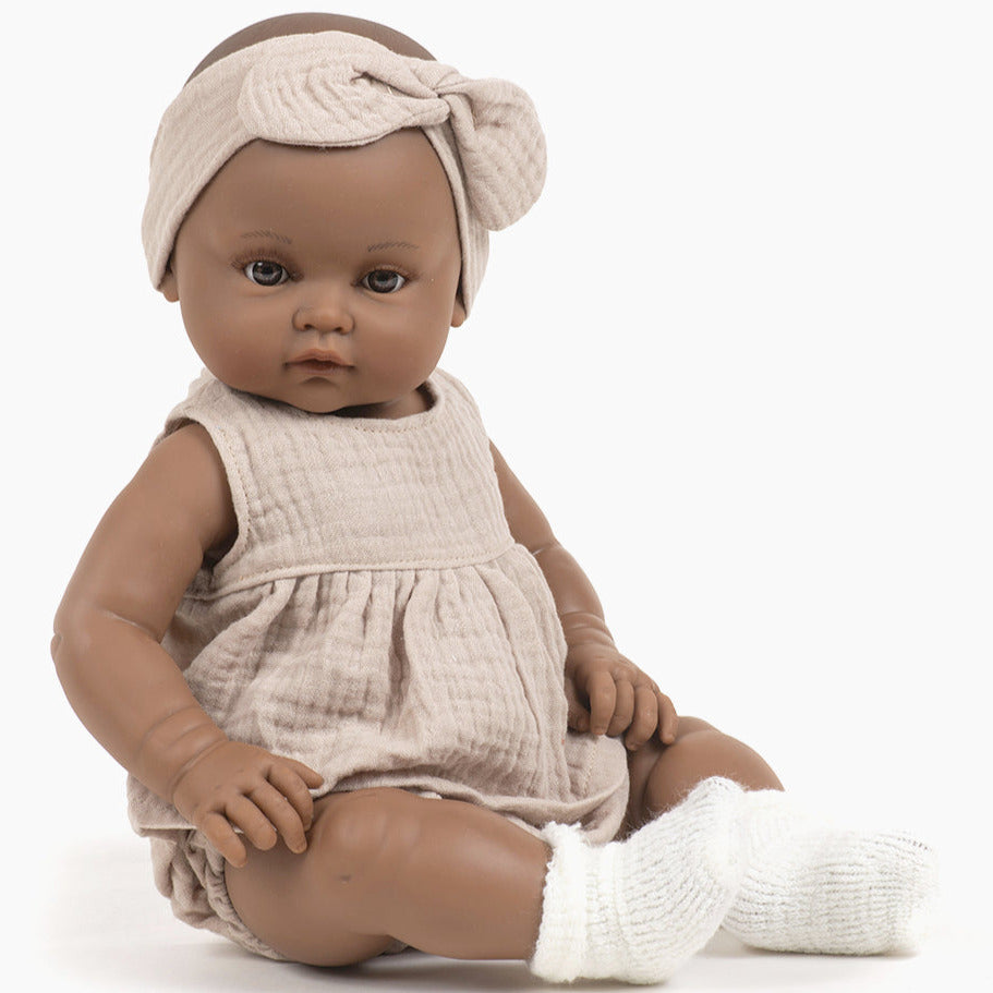 US stockist of Minikane's Augustine Bambini girl doll in her Beige cotton gauze set with matching headband