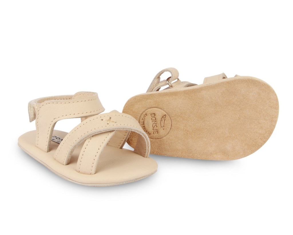 US stockist of Donsje USA's Giggles premium handmade leather sandals.  Cream in color with velcro fastening at back.  Sizes 0-12 mths have soft sole, 12-30mths have a soft flexible, rubber sole.