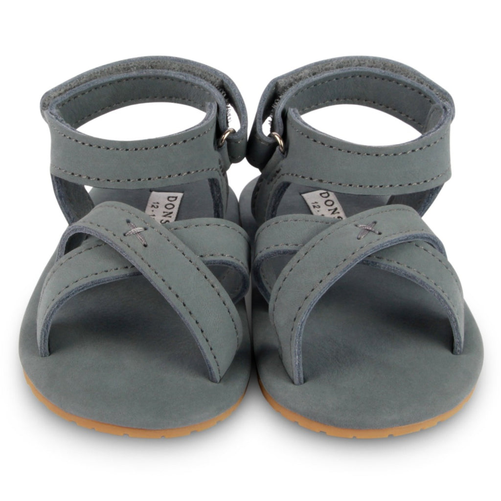 US stockist of Donsje USA's Giggles premium handmade leather nubuck sandals.  Petrol Grey in color with velcro fastening at back.  Sizes 0-12 mths have soft sole, 12-30mths have a soft flexible, rubber sole.