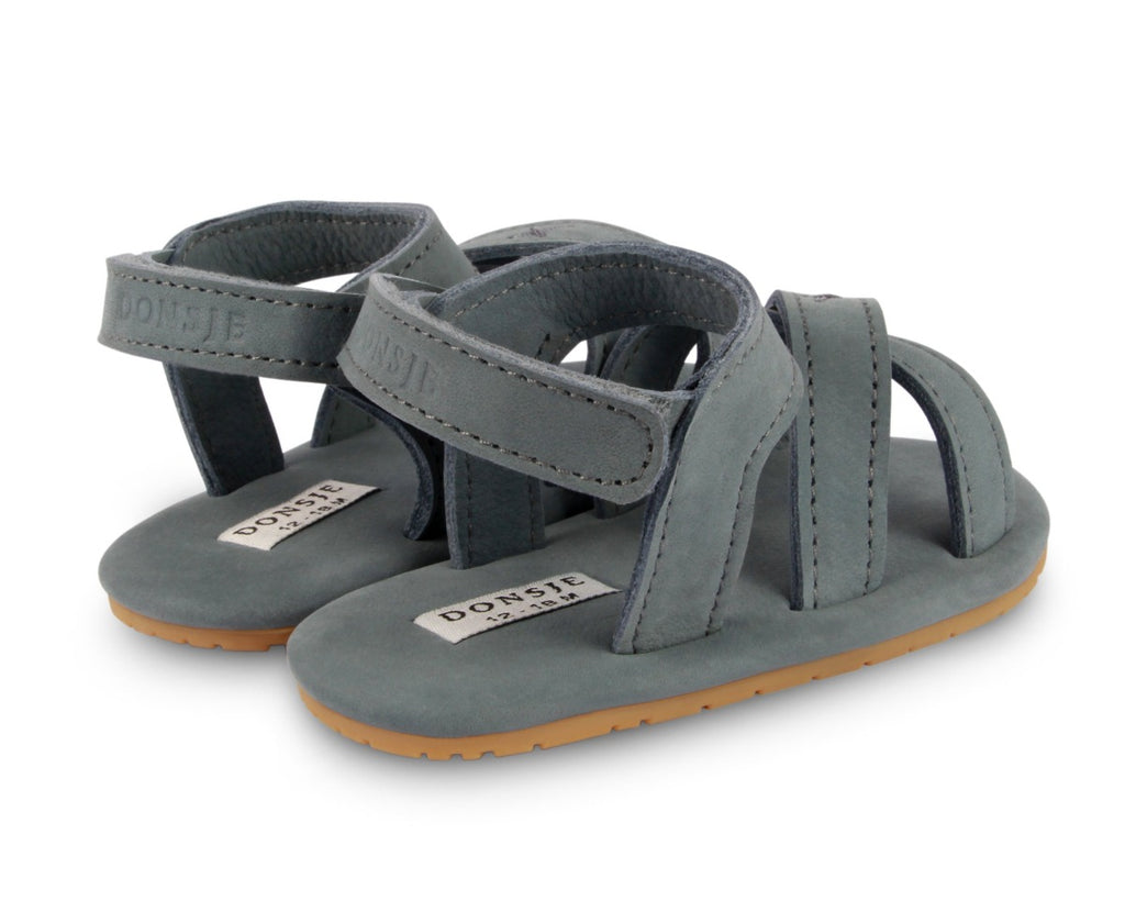 US stockist of Donsje USA's Giggles premium handmade leather nubuck sandals.  Petrol Grey in color with velcro fastening at back.  Sizes 0-12 mths have soft sole, 12-30mths have a soft flexible, rubber sole.