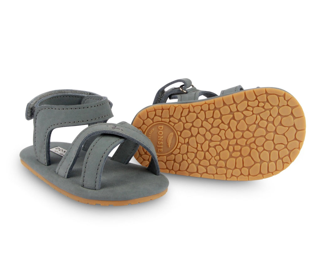 US stockist of Donsje USA's Giggles premium handmade leather nubuck sandals.  Petrol Grey in color with velcro fastening at back.  Sizes 0-12 mths have soft sole, 12-30mths have a soft flexible, rubber sole.