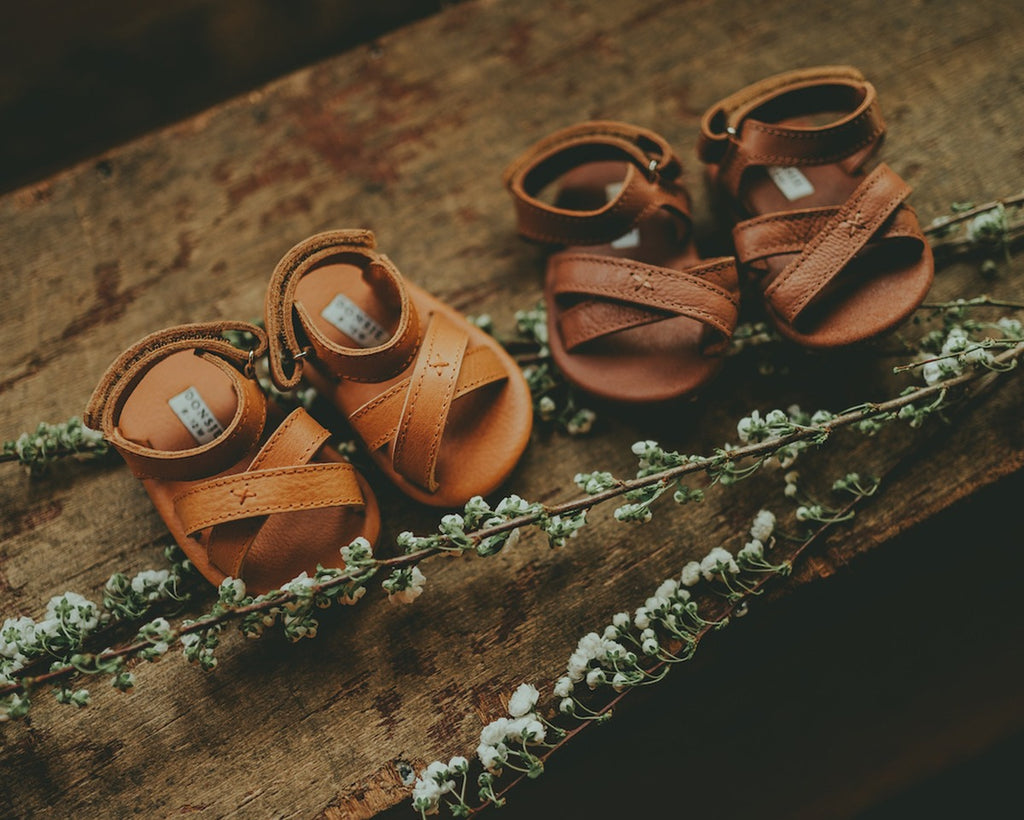 US stockist of Donsje USA's Giggles premium handmade leather sandals.  Cream in color with velcro fastening at back.  Sizes 0-12 mths have soft sole, 12-30mths have a soft flexible, rubber sole.