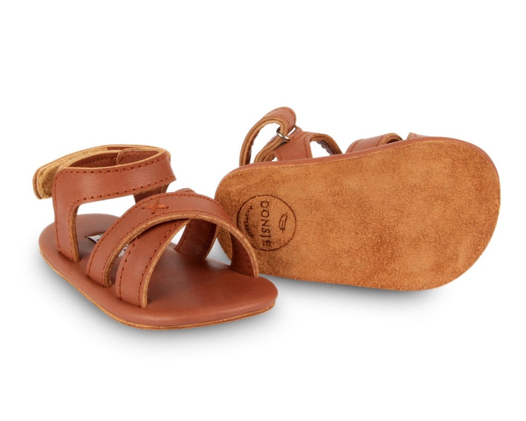 US stockist of Donsje USA's Giggles premium handmade leather sandals.  Cream in color with velcro fastening at back.  Sizes 0-12 mths have soft sole, 12-30mths have a soft flexible, rubber sole.