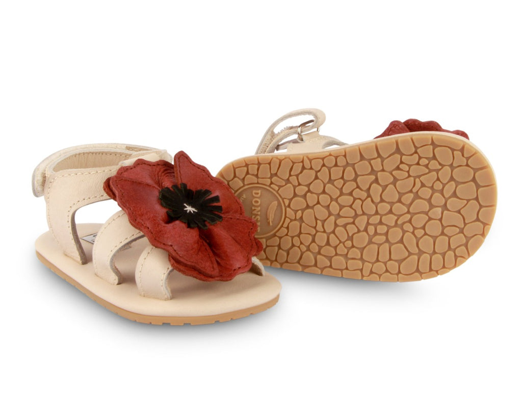US stockist of Donsje USA's Poppy Tuti Fields premium handmade leather sandals.  Cream in color with beautiful red poppy on front and velcro fastening at back.  Sizes 0-12 mths have soft sole, 12-30mths have a soft flexible, rubber sole.