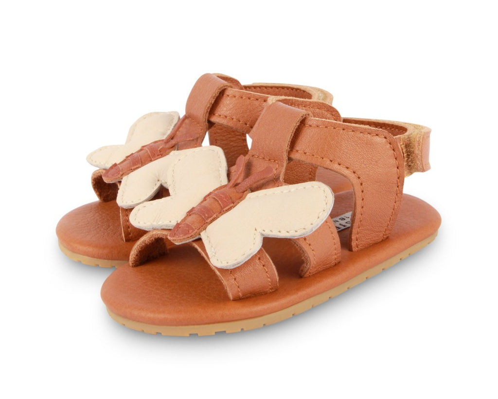 US stockist of Donsje USA's Honey Bee Tuti Sky  premium handmade leather sandals.  Tan in color with beautiful tan/cream honey bee on front and velcro fastening at back.  Sizes 0-12 mths have soft sole, 12-30mths have a soft flexible, rubber sole.