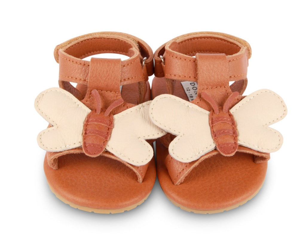 US stockist of Donsje USA's Honey Bee Tuti Sky  premium handmade leather sandals.  Tan in color with beautiful tan/cream honey bee on front and velcro fastening at back.  Sizes 0-12 mths have soft sole, 12-30mths have a soft flexible, rubber sole.