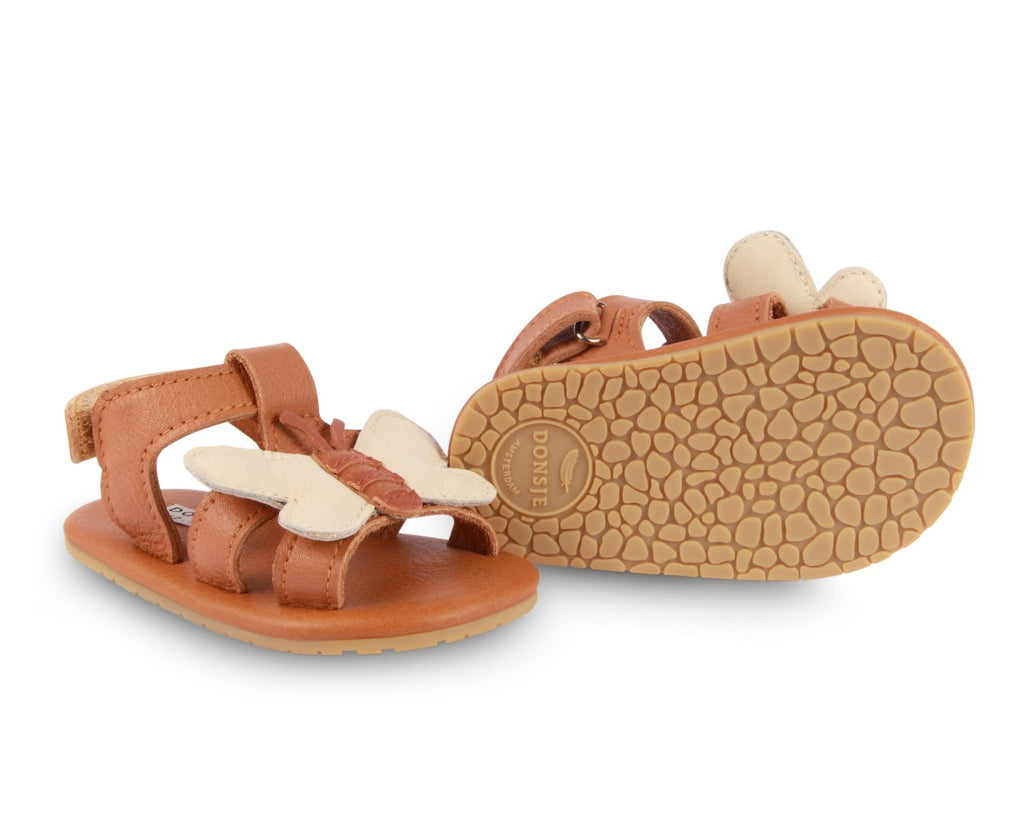 US stockist of Donsje USA's Honey Bee Tuti Sky  premium handmade leather sandals.  Tan in color with beautiful tan/cream honey bee on front and velcro fastening at back.  Sizes 0-12 mths have soft sole, 12-30mths have a soft flexible, rubber sole.