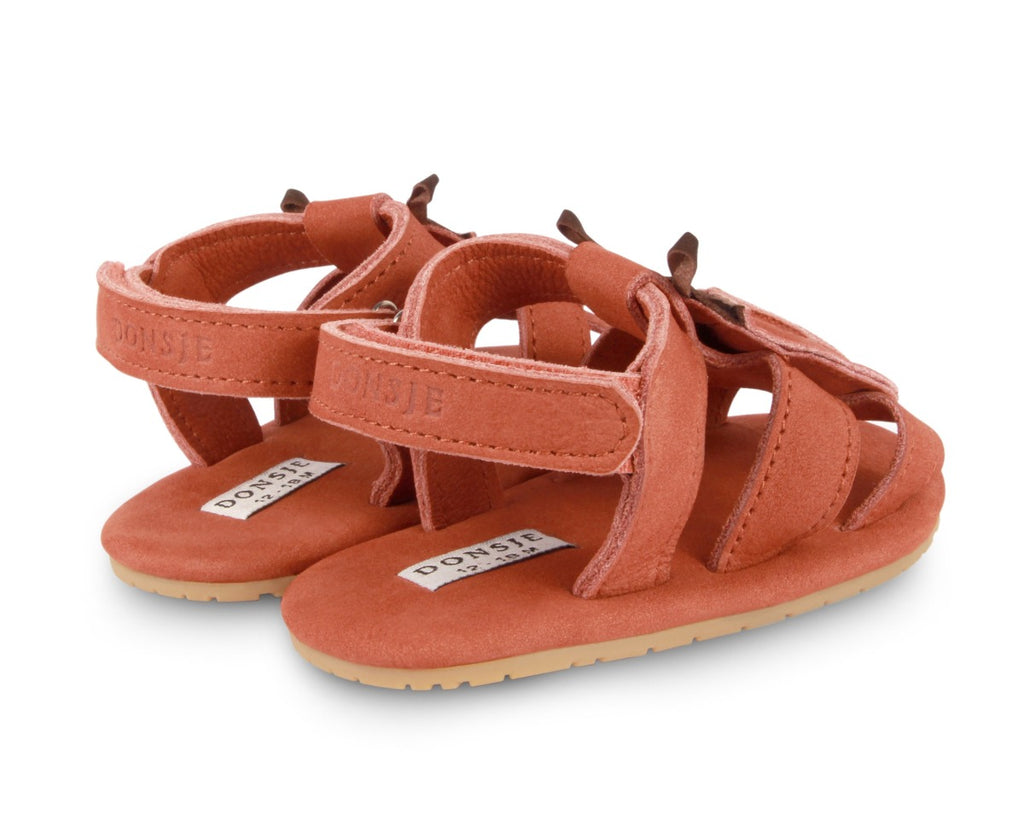 US stockist of Donsje USA's Lady Bird Tuti Sky  premium handmade leather sandals.  Red in color with beautiful lady bird on front and velcro fastening at back.  Sizes 0-12 mths have soft sole, 12-30mths have a soft flexible, rubber sole.
