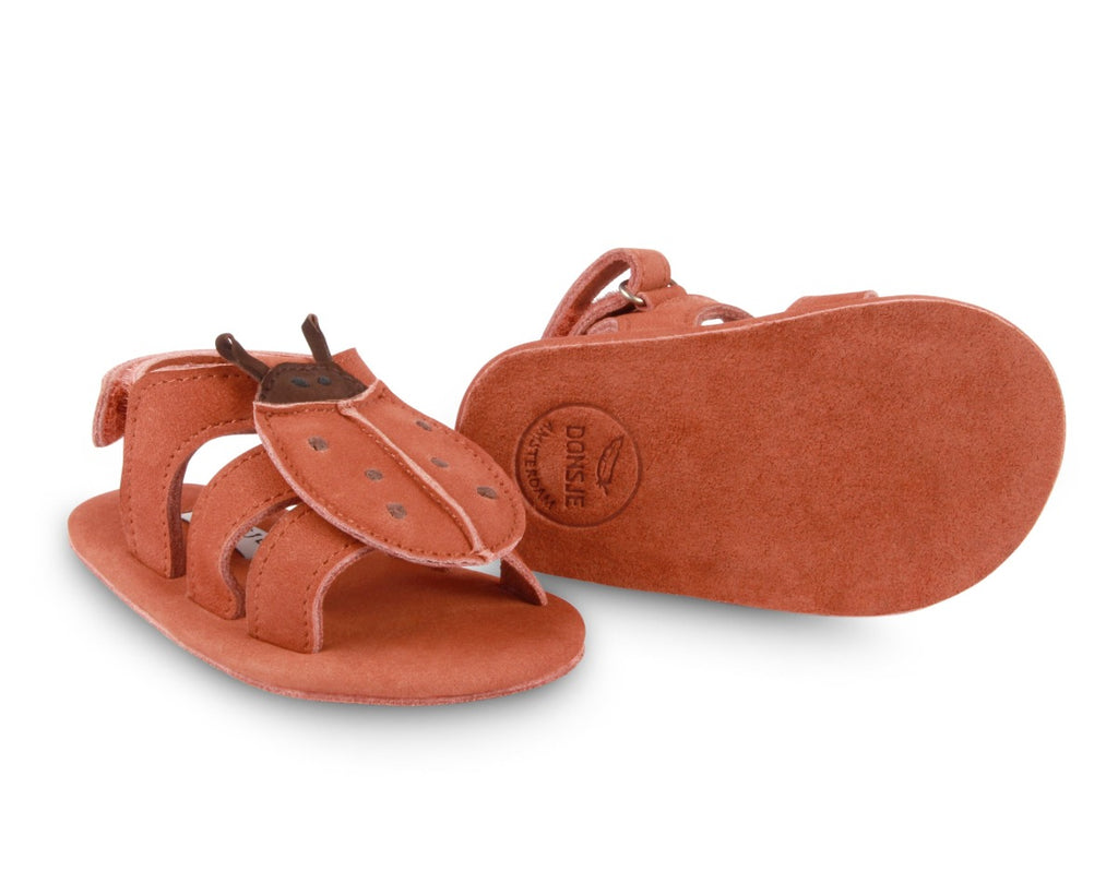 US stockist of Donsje USA's Lady Bird Tuti Sky  premium handmade leather sandals.  Red in color with beautiful lady bird on front and velcro fastening at back.  Sizes 0-12 mths have soft sole, 12-30mths have a soft flexible, rubber sole.