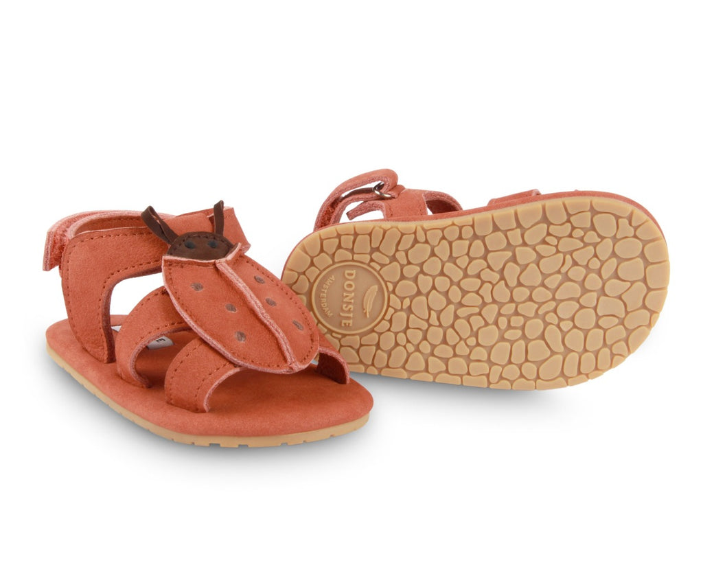 US stockist of Donsje USA's Lady Bird Tuti Sky  premium handmade leather sandals.  Red in color with beautiful lady bird on front and velcro fastening at back.  Sizes 0-12 mths have soft sole, 12-30mths have a soft flexible, rubber sole.