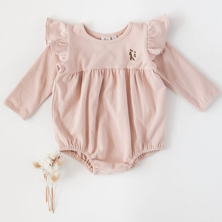 US stockist of Karibou Kid's Milana Winged Playsuit in soft pink.  Made from soft cotton, featuring long sleeves and ruffled wings at shoulders.