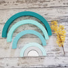 US stockist of Children of the Trees handmade 6pc rainbow stacker wooden toy in shades of aqua blue.