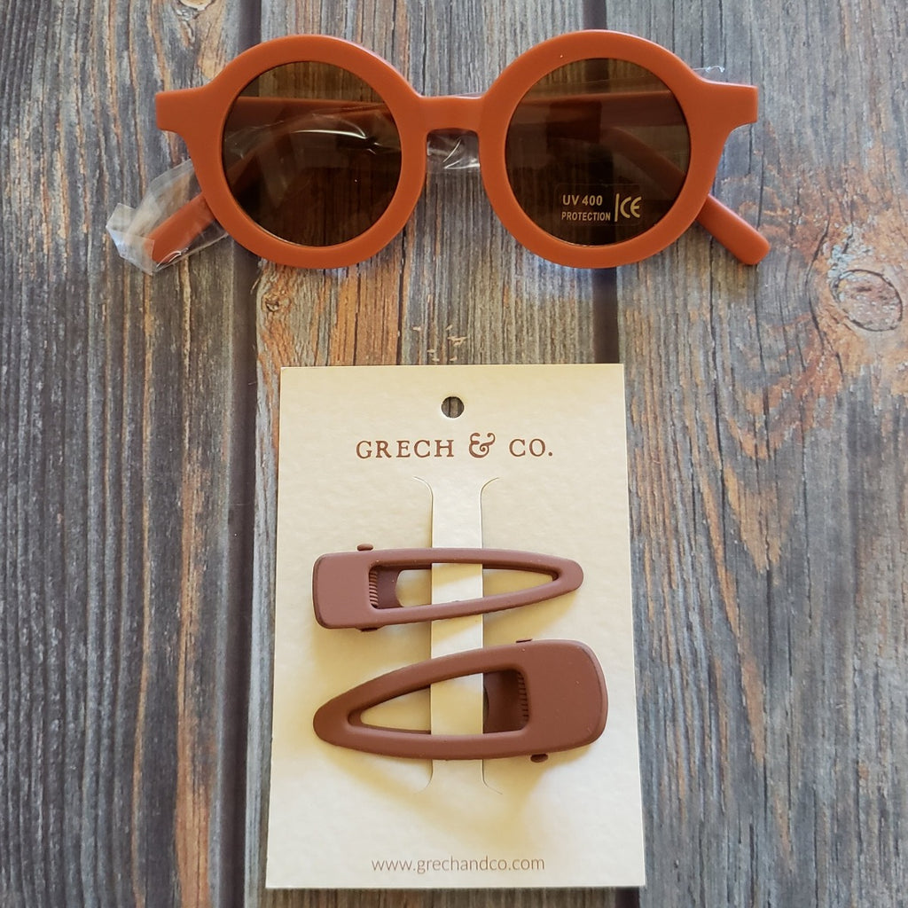 US stockist of Grech & Co's gender neutral sustainable sunglasses.  Made from recycled plastic, with round amber lens with UV 400 protection in a rust color.