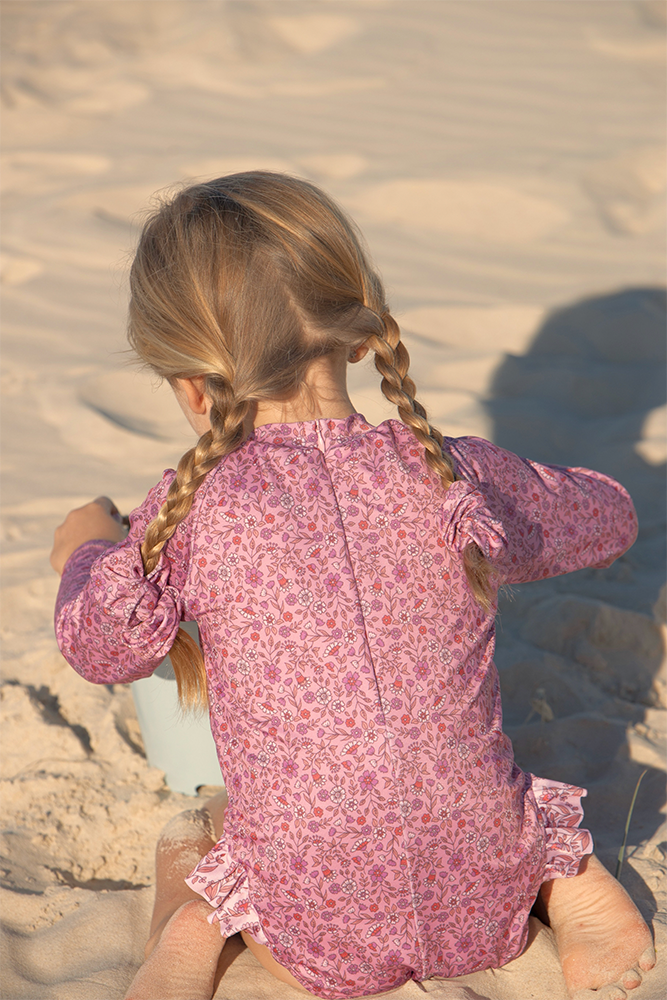 US stockist of Salty Swimwear's Zoe long sleeve rashsuit in candy wildflowers.  Made from pink UPF 50+ recycled Repreve fabric with pretty wildflower print. Fully lined, with invisible back zipper and signature Salty frill on legs.