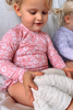 US stockist of Salty Swimwear's Zoe long sleeve rashsuit in pink daisy days.  Made from pink UPF 50+ recycled Repreve fabric with pretty white daisy print. Fully lined, with invisible back zipper and signature Salty frill on legs.