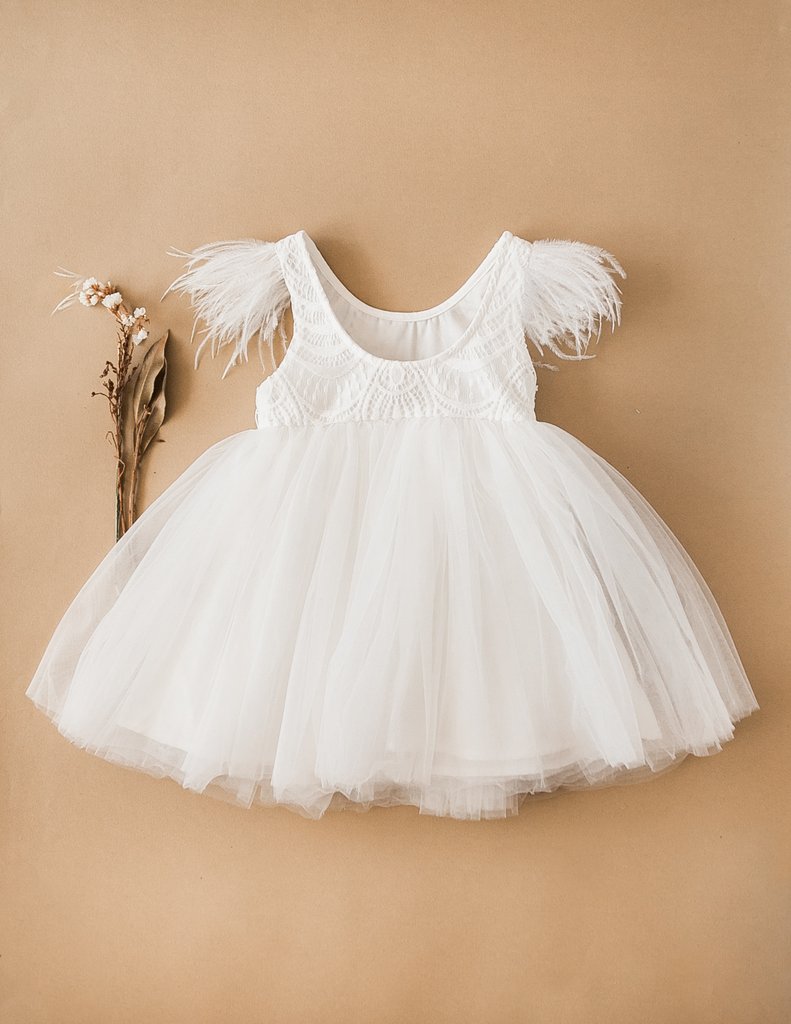 US stockist of Karibou Kids white Angelina Feather and Lace Dress.  Features 5 layer full skirt, lace bodice, scoop back and ostrich feather flutter sleeves. 