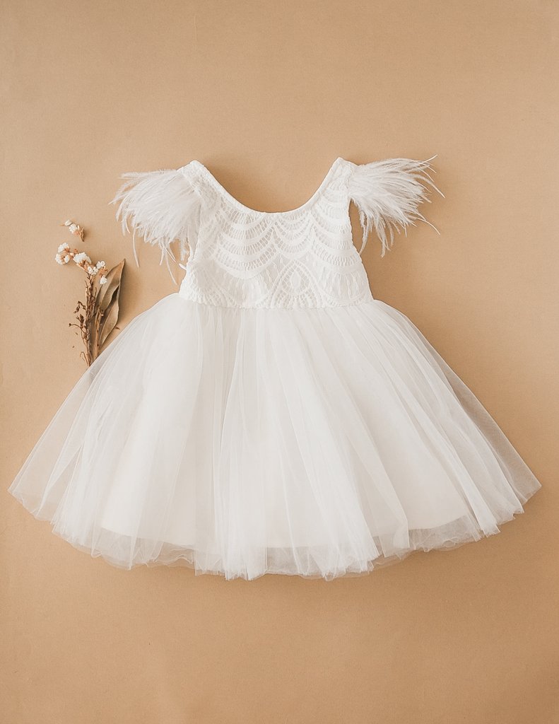 US stockist of Karibou Kids white Angelina Feather and Lace Dress.  Features 5 layer full skirt, lace bodice, scoop back and ostrich feather flutter sleeves. 