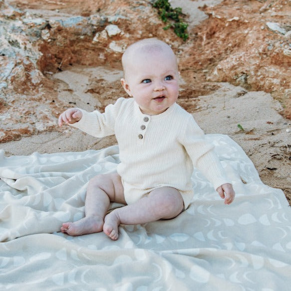 US stockist of Grown Clothing's gender neutral, organic cotton ribbed button bodysuit in Milk.
