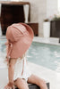 US stockist of Fini the Label's gender neutral, floppy swim hat in cocoa. Features elongated back for added sun protection, chin strap and adjustable bow around crown for better fit. Brim is medium stiffness and can be flipped up at front.  Made from nylon/spandex and is quick drying.