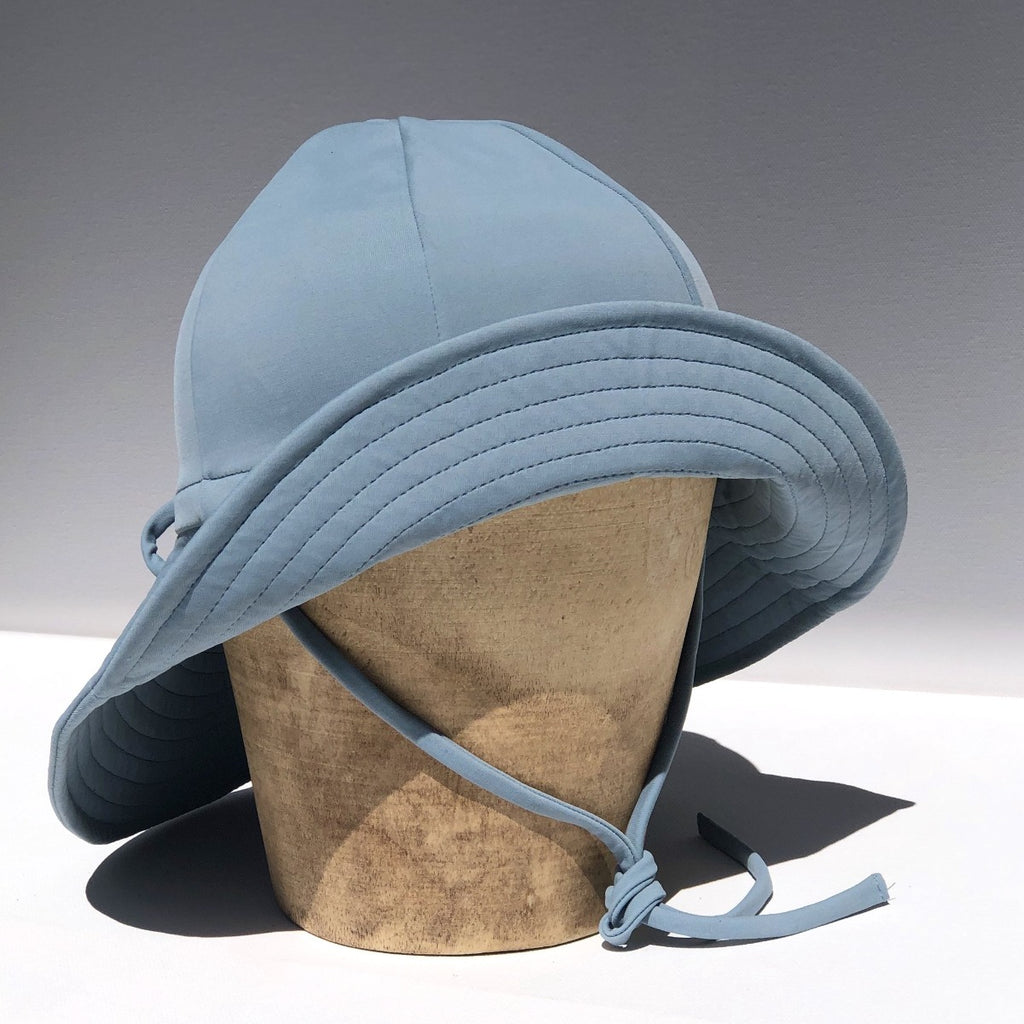 US stockist of Fini the Label's gender neutral, floppy swim hat in heaven. Features elongated back for added sun protection, chin strap and adjustable bow around crown for better fit. Brim is medium stiffness and can be flipped up at front.  Made from nylon/spandex and is quick drying.