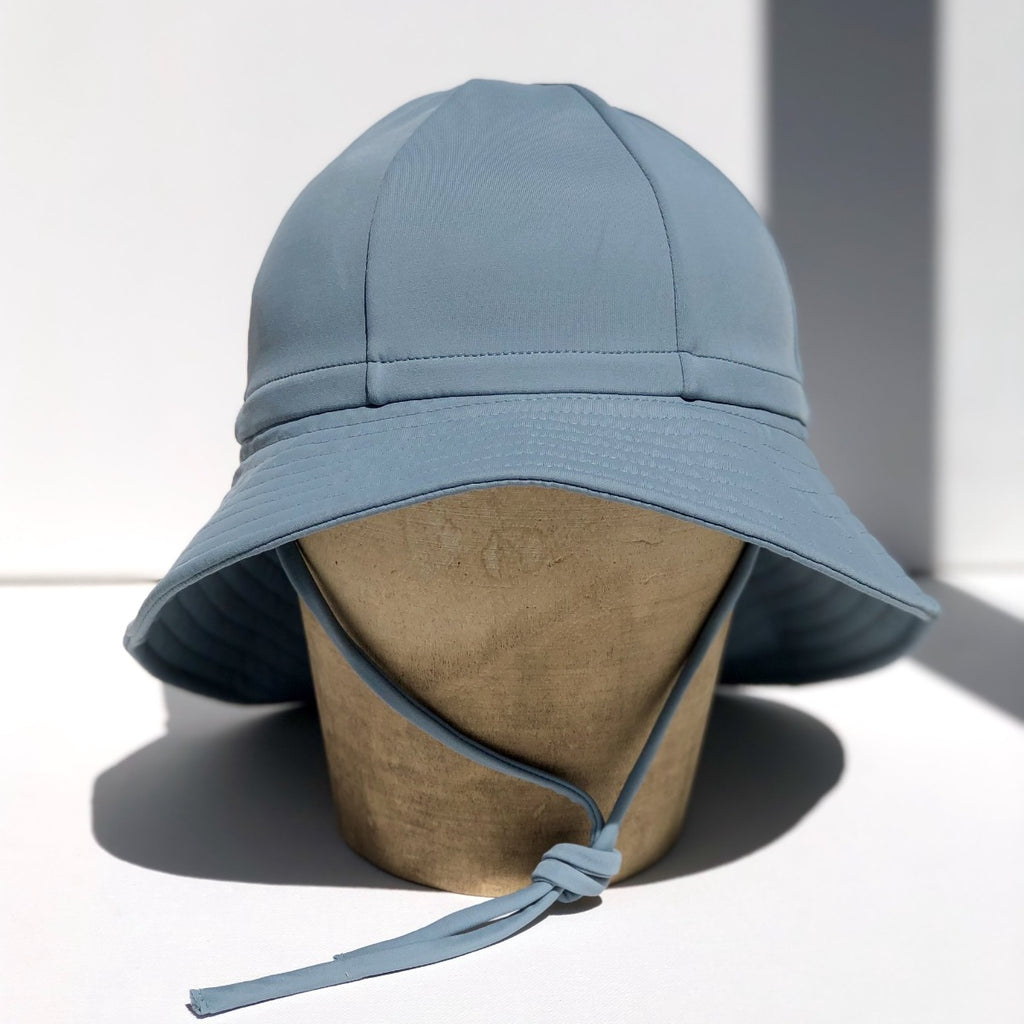 US stockist of Fini the Label's gender neutral, floppy swim hat in heaven. Features elongated back for added sun protection, chin strap and adjustable bow around crown for better fit. Brim is medium stiffness and can be flipped up at front.  Made from nylon/spandex and is quick drying.