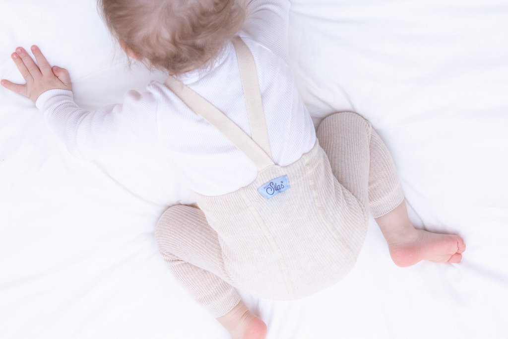 US stockist of Silly Silas gender neutral retro ribbed footed tights in cream blend.  Made from 100% cotton and featuring braces.