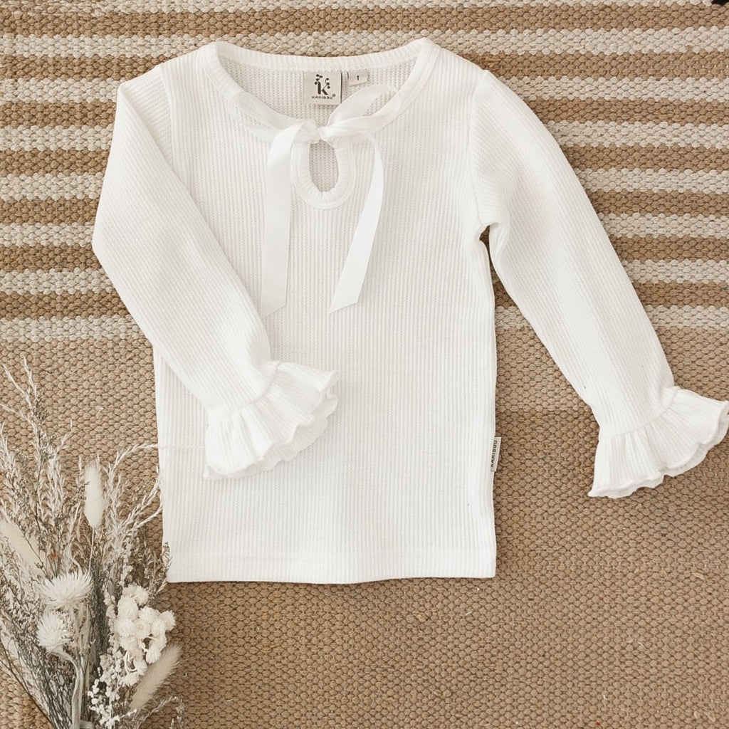US stockist of Karibou Kids' whimsy love ruffle sleeve, cotton waffle top in snow white.  Features keyhole tie front of neck.