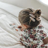 US stockist of Josie Joan's Lillia set of two fabric hair clips.  Cream colored fabric with pastel flowers in hues of pink, purple, blue and with green foilage. Features scalloped edges.