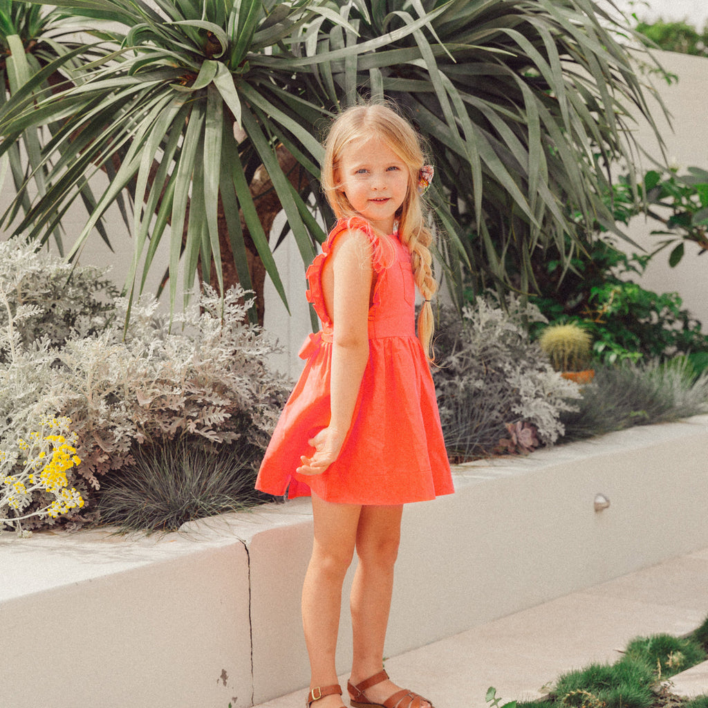 US stockist of Lacey Lane's cotton Melanie Bib dress in soft watermelon red.