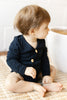 US stockist of Two Darling's long sleeve bamboo/cotton midnight blue bodysuit. Kimono style crossover front with four functioning wooden buttons.  Snaps at crotch.