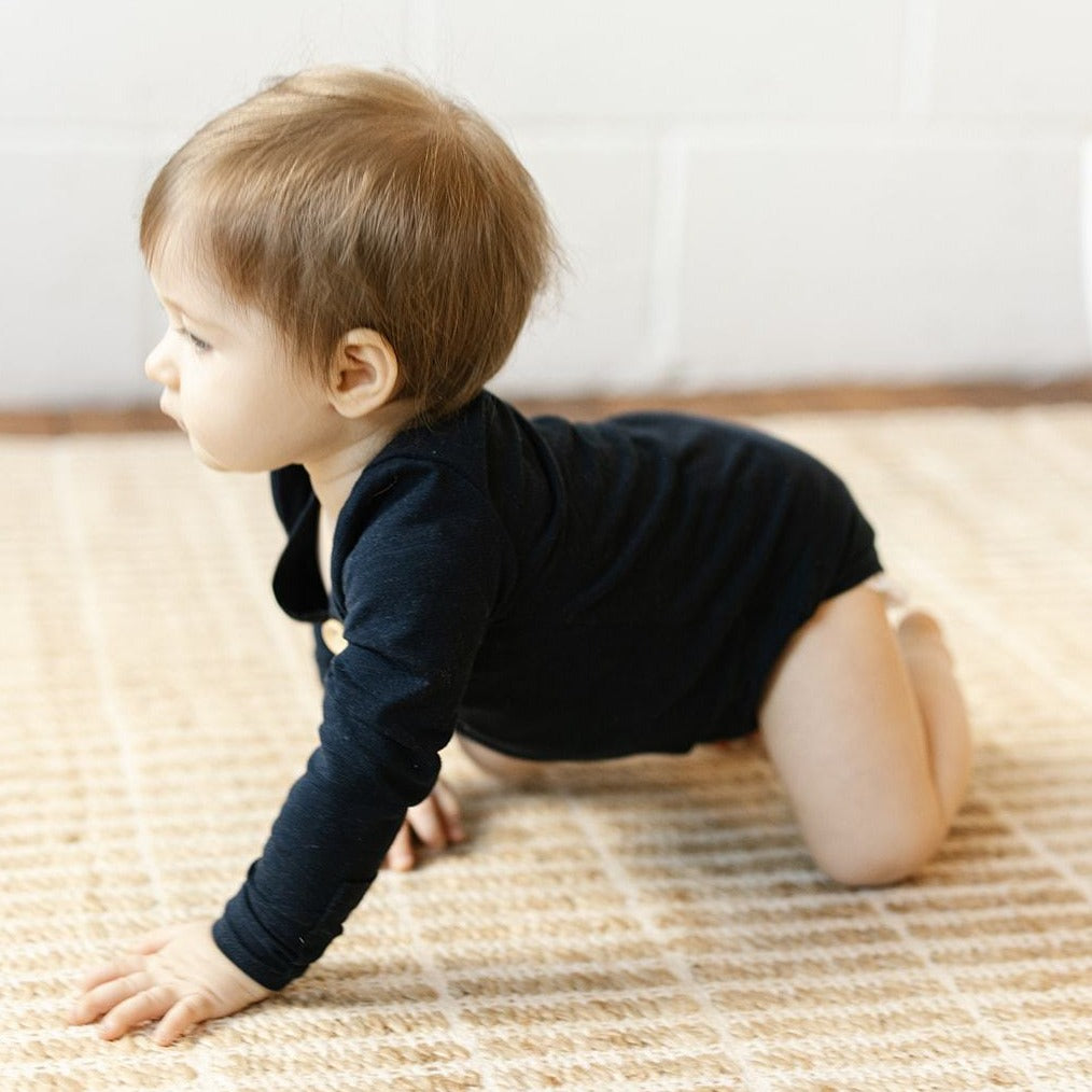 US stockist of Two Darling's long sleeve bamboo/cotton midnight blue bodysuit. Kimono style crossover front with four functioning wooden buttons.  Snaps at crotch.
