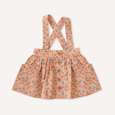 US stockist of Lacey Lane's Peach suspender skirt.  Peach cotton fabric with a pretty design of white and blue flowers.  Features pockets and oversized buttons down front.