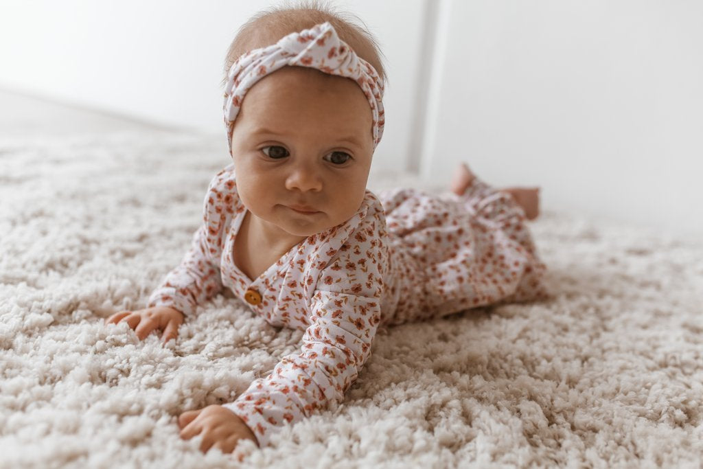 US stockist of Two Darlings gender neutral Posey Floral stretch cotton bodysuit. Long Sleeves with 4 non functional wooden buttons kimono style across the front.