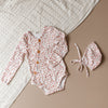 US stockist of Two Darlings gender neutral Posey Floral stretch cotton bodysuit. Long Sleeves with 4 non functional wooden buttons kimono style across the front.