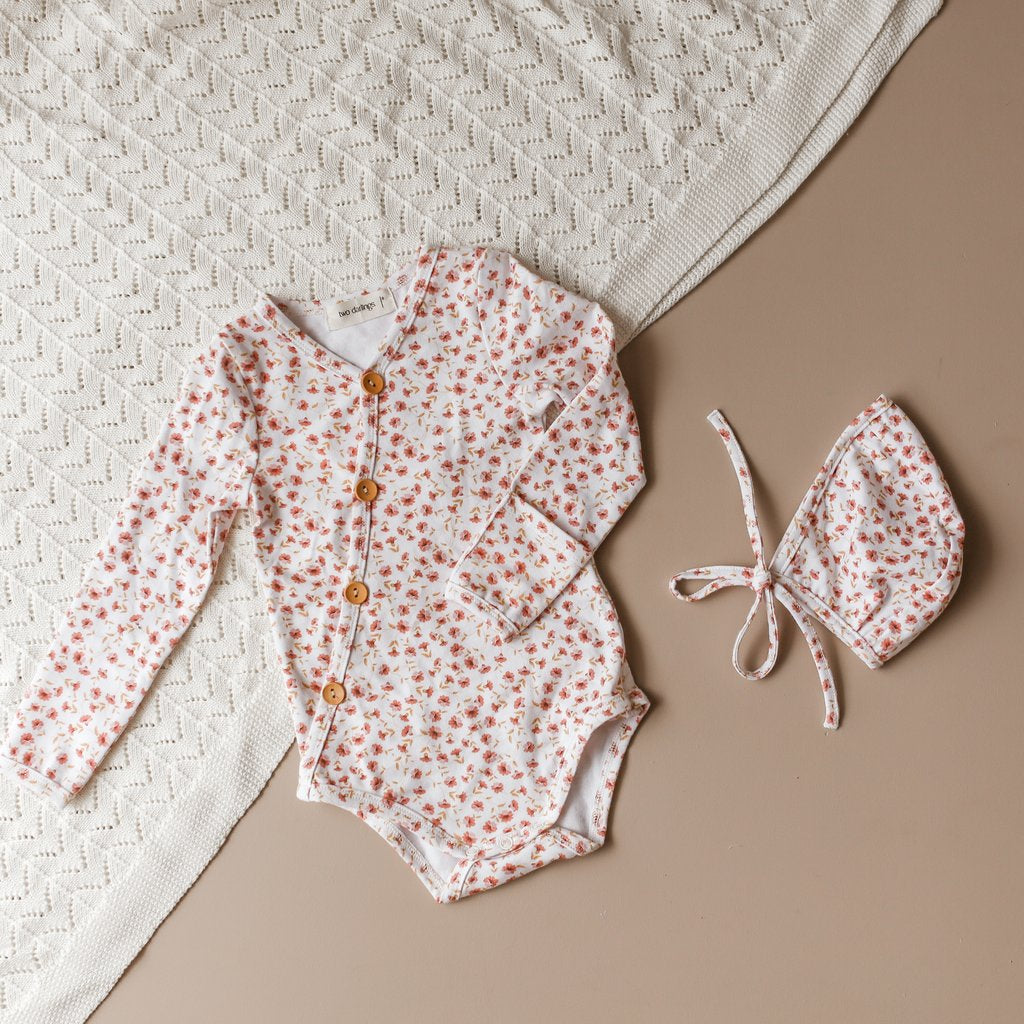 US stockist of Two Darlings gender neutral Posey Floral stretch cotton bodysuit. Long Sleeves with 4 non functional wooden buttons kimono style across the front.