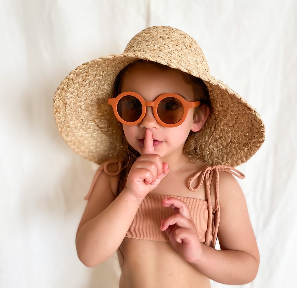 US stockist of Grech & Co's gender neutral sustainable sunglasses.  Made from recycled plastic, with round amber lens with UV 400 protection in a rust color.