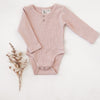 US stockist of Karibou Kids soft pink Willow long sleeve henley bodysuit in ribbed cotton blend.