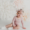 US stockist of Karibou Kids soft pink Willow long sleeve henley bodysuit in ribbed cotton blend.