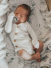 US stockist of Two Darlings gender neutral Milk stretch rib cotton bodysuit. Long Sleeves with 4 non functional wooden buttons kimono style across the front.