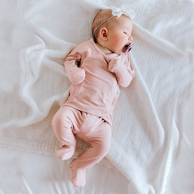 Stockist of Bonsie's rayon blend Peony pink footie.  Top section has velcro wrap body which can be undone for skin to skin contact.  Elastic waist that can be pulled down for easy diaper changes. 