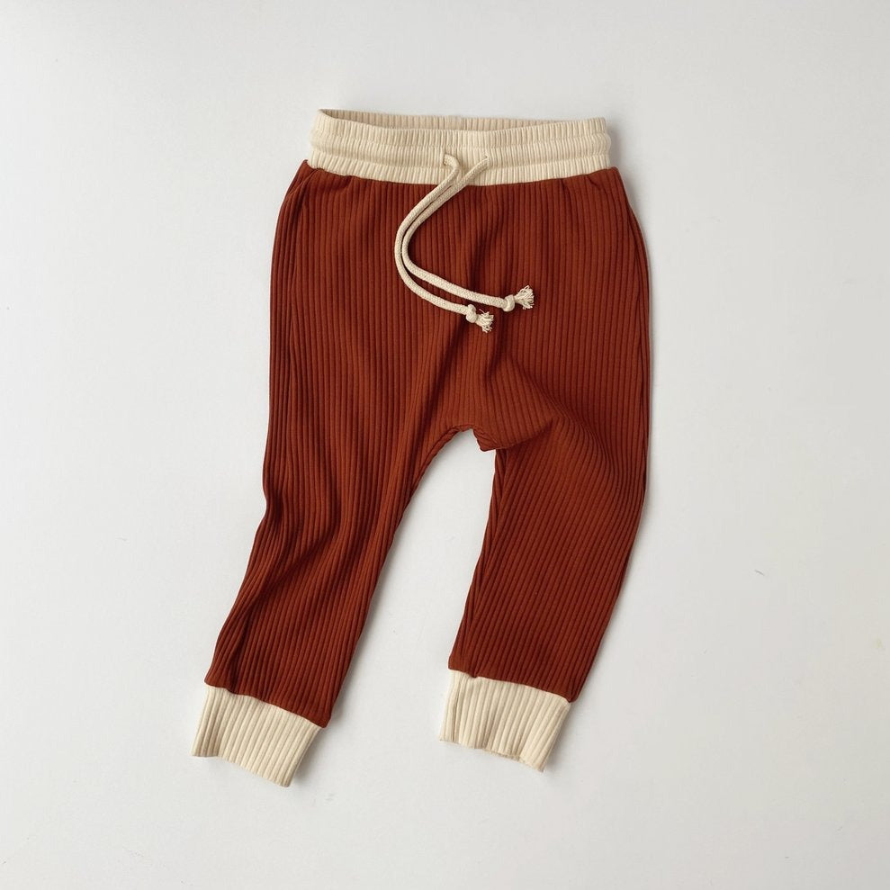US stockist of Bel & Bow's gender neutral ribbed cotton joggers in rust.  Has a contrasing cream cuffs and waistband with functional drawstring.