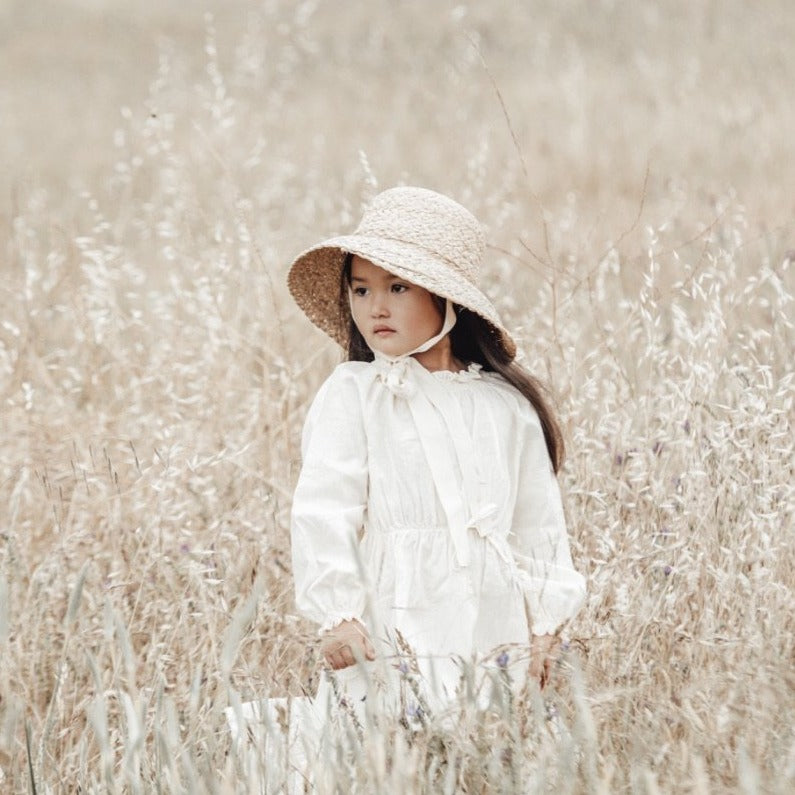 US stockist of Fini the Label's vintage French style straw hat.  Made from raffia straw with a wide bell shaped brim and a trimmed natural ribbon beget chin strap.
