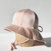 US stockist of Fini the Label's gender neutral, floppy swim hat in Shimmer Champagne. Features elongated back for added sun protection, chin strap and adjustable bow around crown for better fit. Brim is medium stiffness and can be flipped up at front.  Made from nylon/spandex and is quick drying.