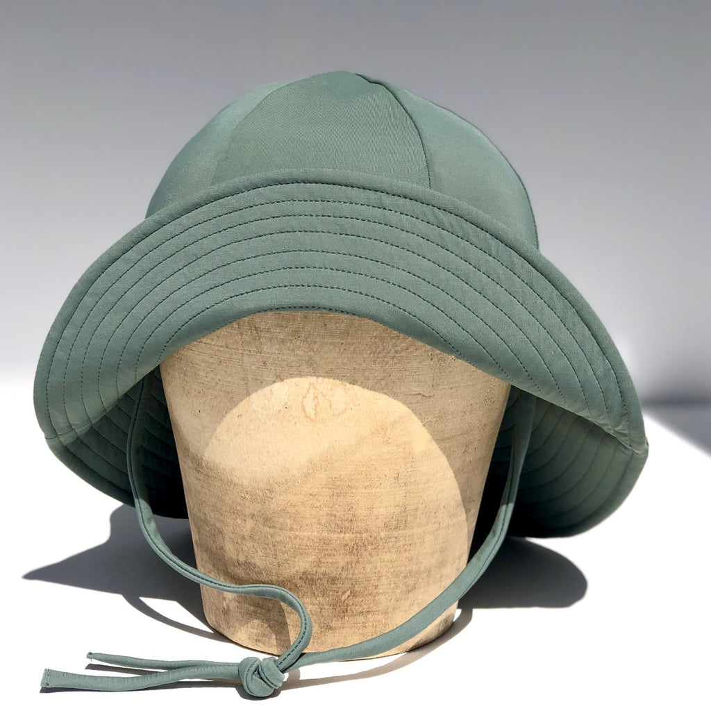 US stockist of Fini the Label's gender neutral, floppy swim hat in Ivy Green. Features elongated back for added sun protection, chin strap and adjustable bow around crown for better fit. Brim is medium stiffness and can be flipped up at front.  Made from nylon/spandex and is quick drying.