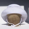 US stockist of Fini the Label's gender neutral, sailor swim hat in white. Features elongated back for added sun protection, wide brim and chin strap. Brim is medium stiffness and can be flipped up at front. Sides can be worn buttoned up for that sailor look.  Made from nylon/spandex and is quick drying.