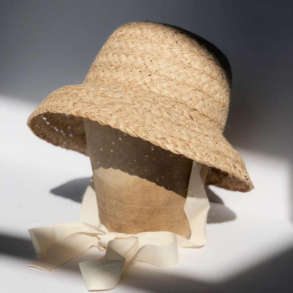 US stockist of Fini the Label's vintage French style straw hat.  Made from raffia straw with a wide bell shaped brim and a trimmed natural ribbon beget chin strap.