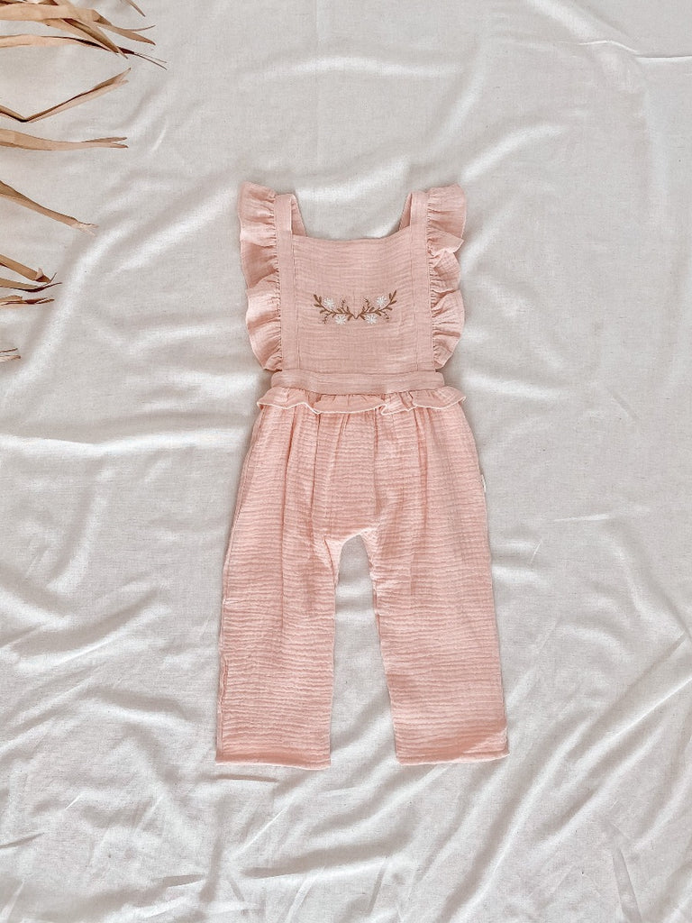 US stockist of India and Grace the Label's vintage pink embroidered ruffle jumpsuit.  Features ruffle straps that cross over the back, floral embroidery on the chest, ruffle at waist and 3/4 legs.  Made from double cotton gauze.
