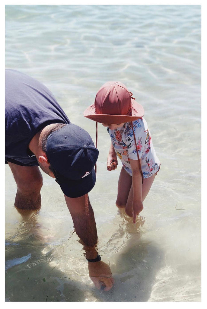 US stockist of Fini the Label's gender neutral, floppy swim hat in marsala. Features elongated back for added sun protection, chin strap and adjustable bow around crown for better fit. Brim is medium stiffness and can be flipped up at front.  Made from nylon/spandex and is quick drying.