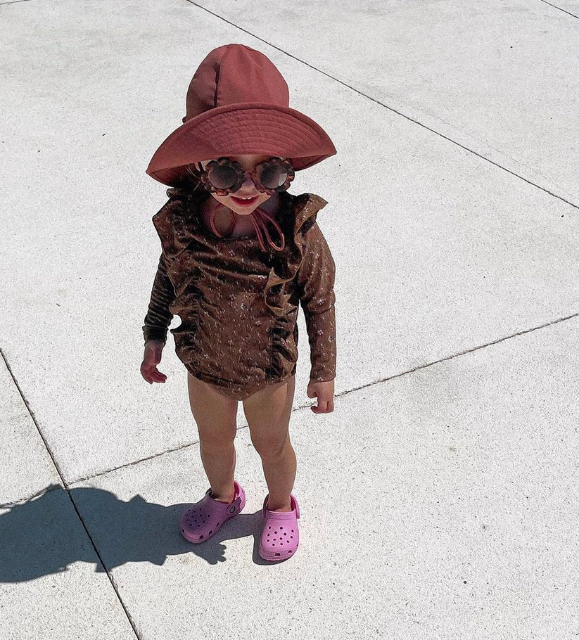 US stockist of Fini the Label's gender neutral, floppy swim hat in marsala. Features elongated back for added sun protection, chin strap and adjustable bow around crown for better fit. Brim is medium stiffness and can be flipped up at front.  Made from nylon/spandex and is quick drying.