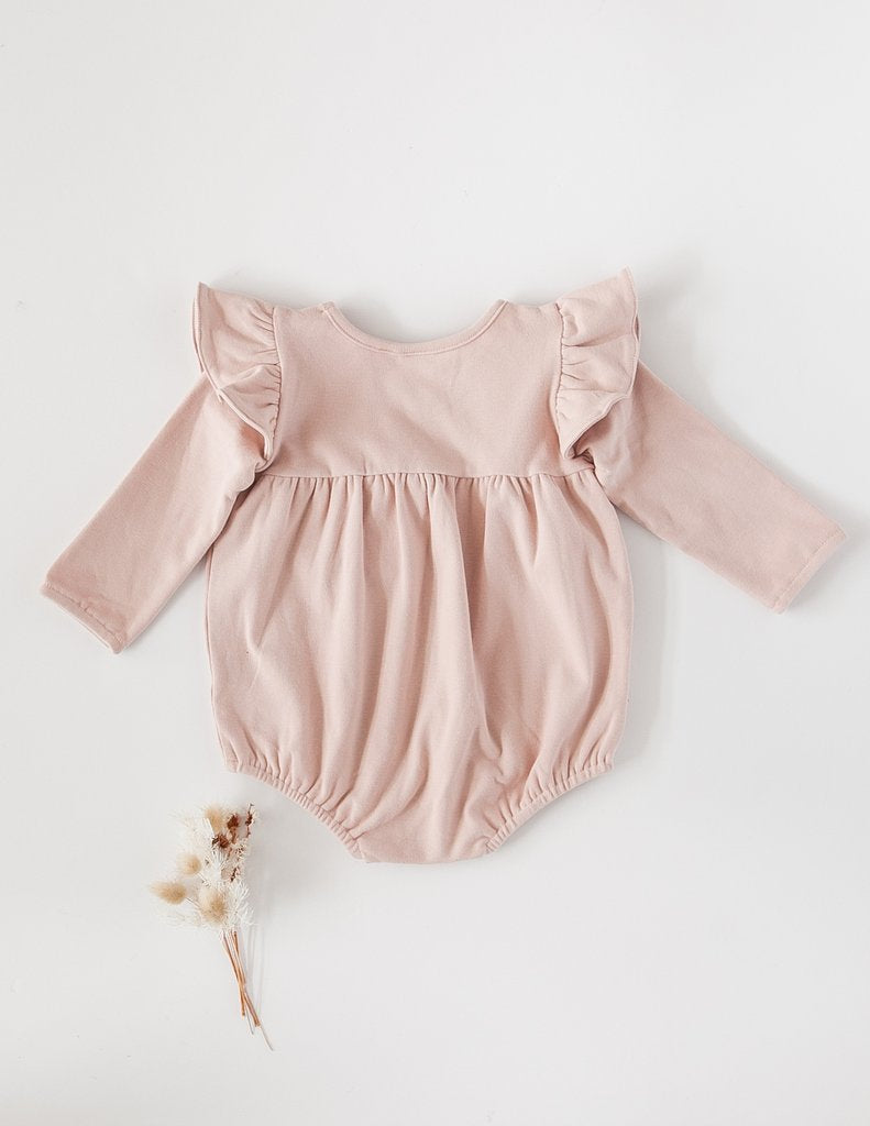 US stockist of Karibou Kid's Milana Winged Playsuit in soft pink.  Made from soft cotton, featuring long sleeves and ruffled wings at shoulders.